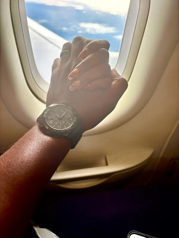 Holding hands by an aeroplane window